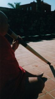 De vakantie-didgeridoo wordt bespeeld op een terras, met de didgeridoo schuin vooruit