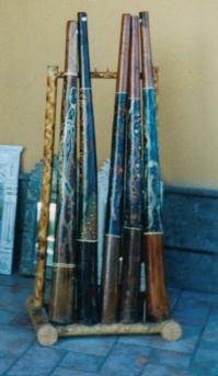 Rek met didgeridoo's van Indonesisch teakhout voor de deur van een winkeltje
